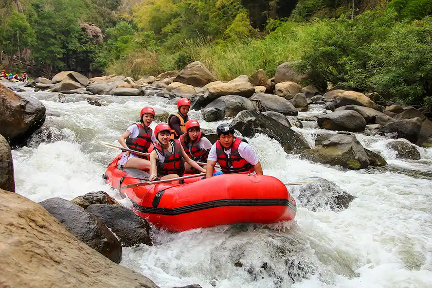 A group of young people having fun while water rafting